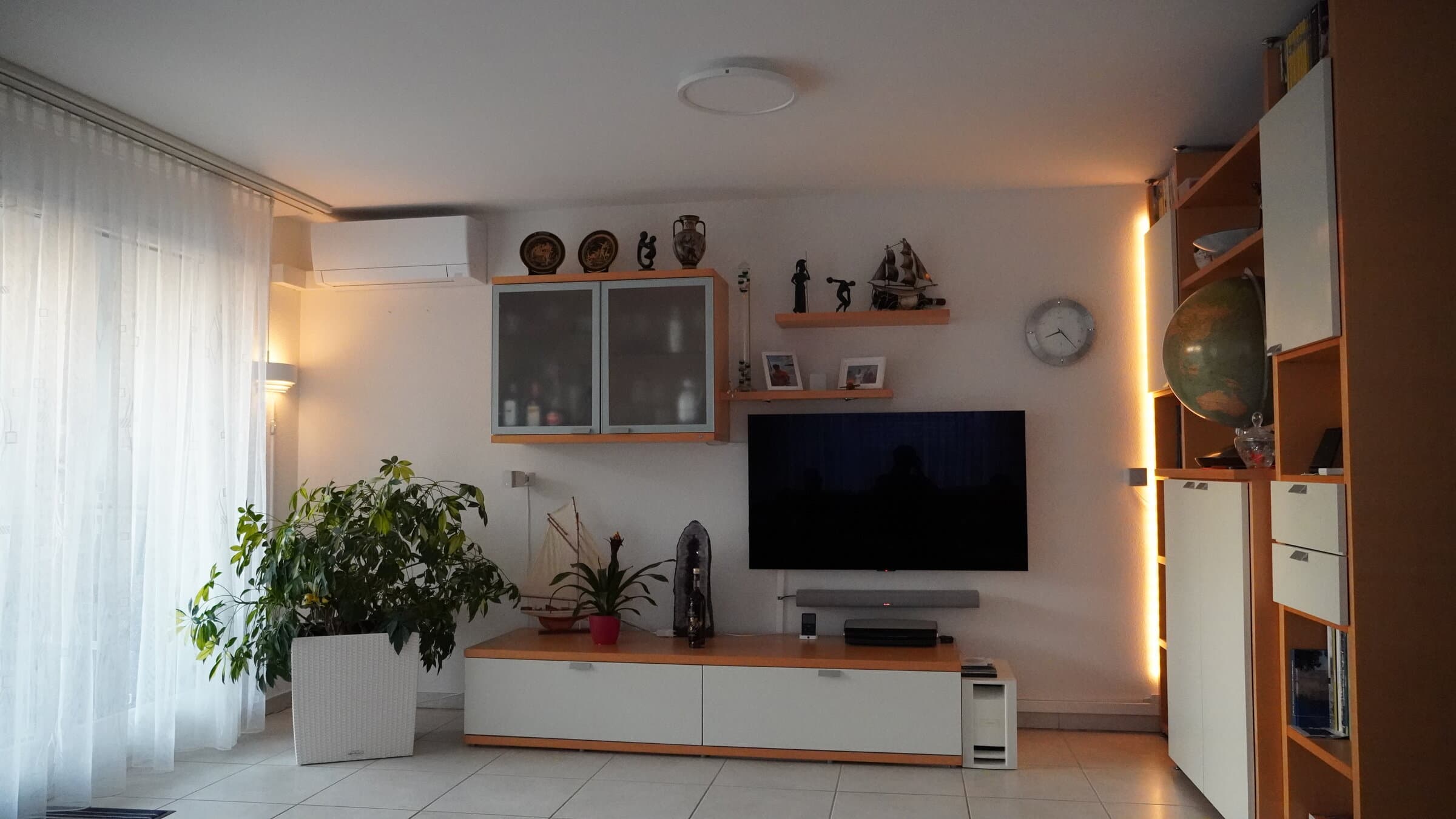 Wohnzimmer des Referenzprojekts am Abend - warmes Ambientelicht mit Philips-Hue-System, Reinach BL
